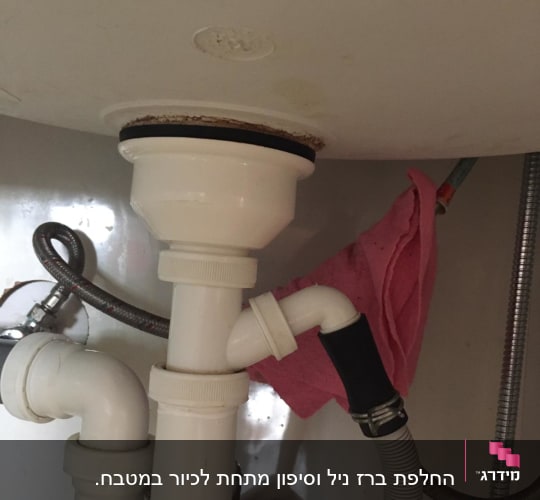צנרת פלסטיק מתחת לכיור עם חיבורי מתכת
